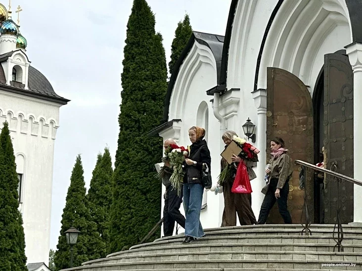 Mourners at a funeral, some looking solemn