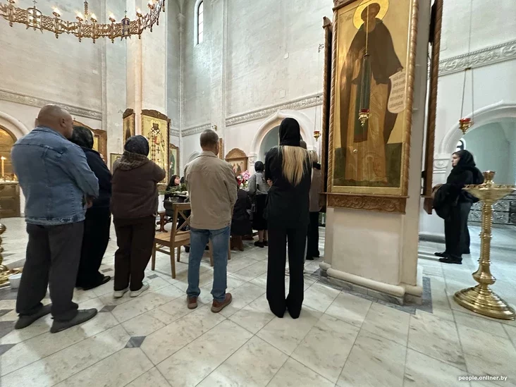 People carrying flowers into a church for a funeral