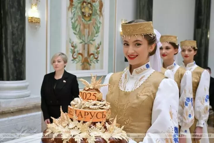 Елизавета Казак несет каравай во время вручения наград заслуженным аграриям Беларуси. Минск, ноябрь 2025. Фото: БелТА